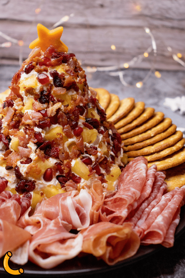 Christmas tree cheese ball with a selection of crackers and meats