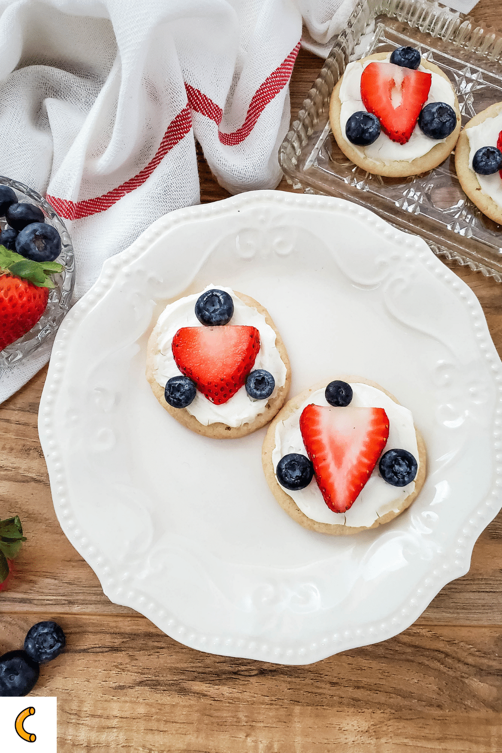 Cookies topped with cream cheese frosting, blueberries, and strawberries for a delicious 4th of July treat the whole family will enjoy!