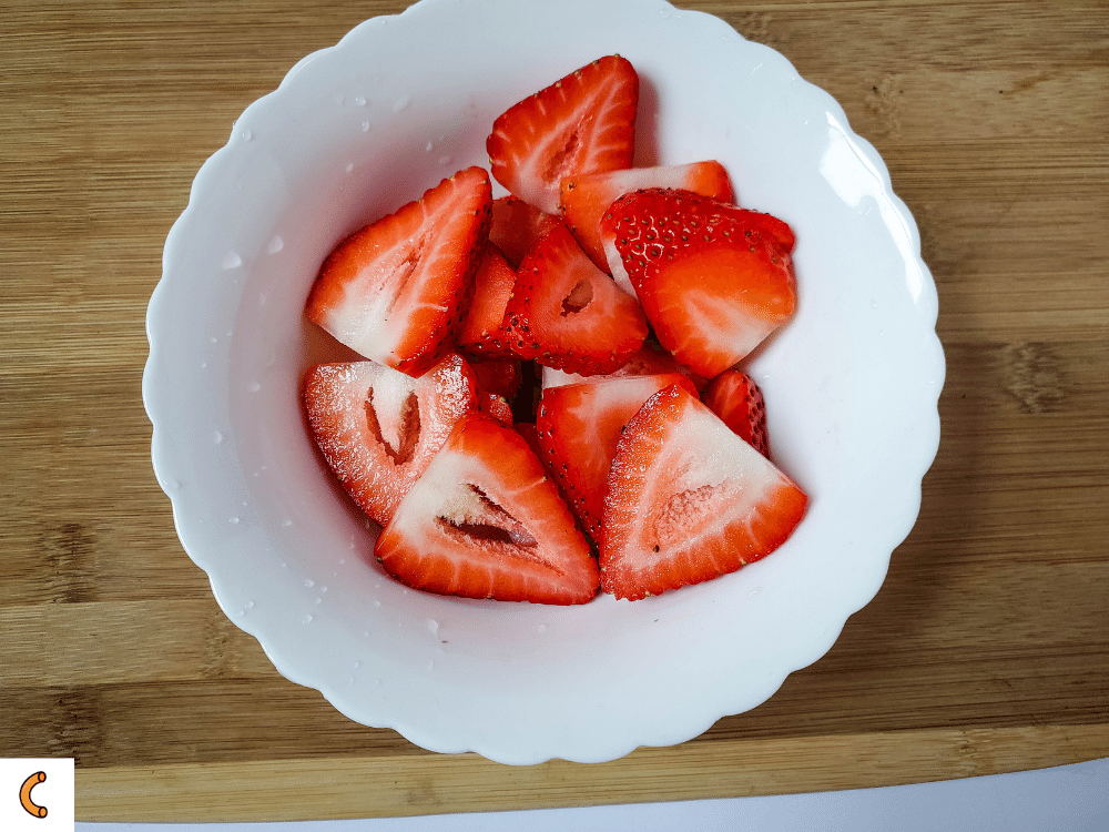 While cookies are cooling, rinse and remove the stems from the strawberries. Then cup off the sides, and slice the remaining strawberry into 2-3 slices.